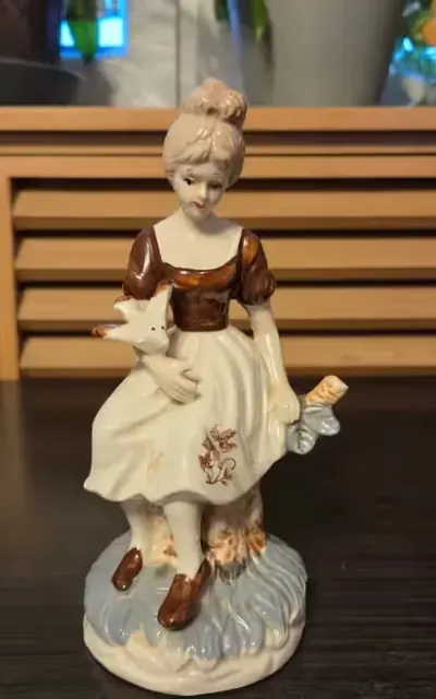 Porcelanowa figurka dziewczyny z ptakiem nieznanej produkcji — praca Filip, Łódź